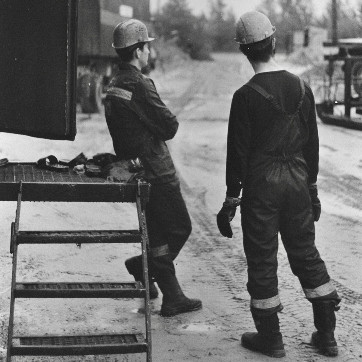 Zwei Männer in schwarzer Kleidung auf grauer Bank